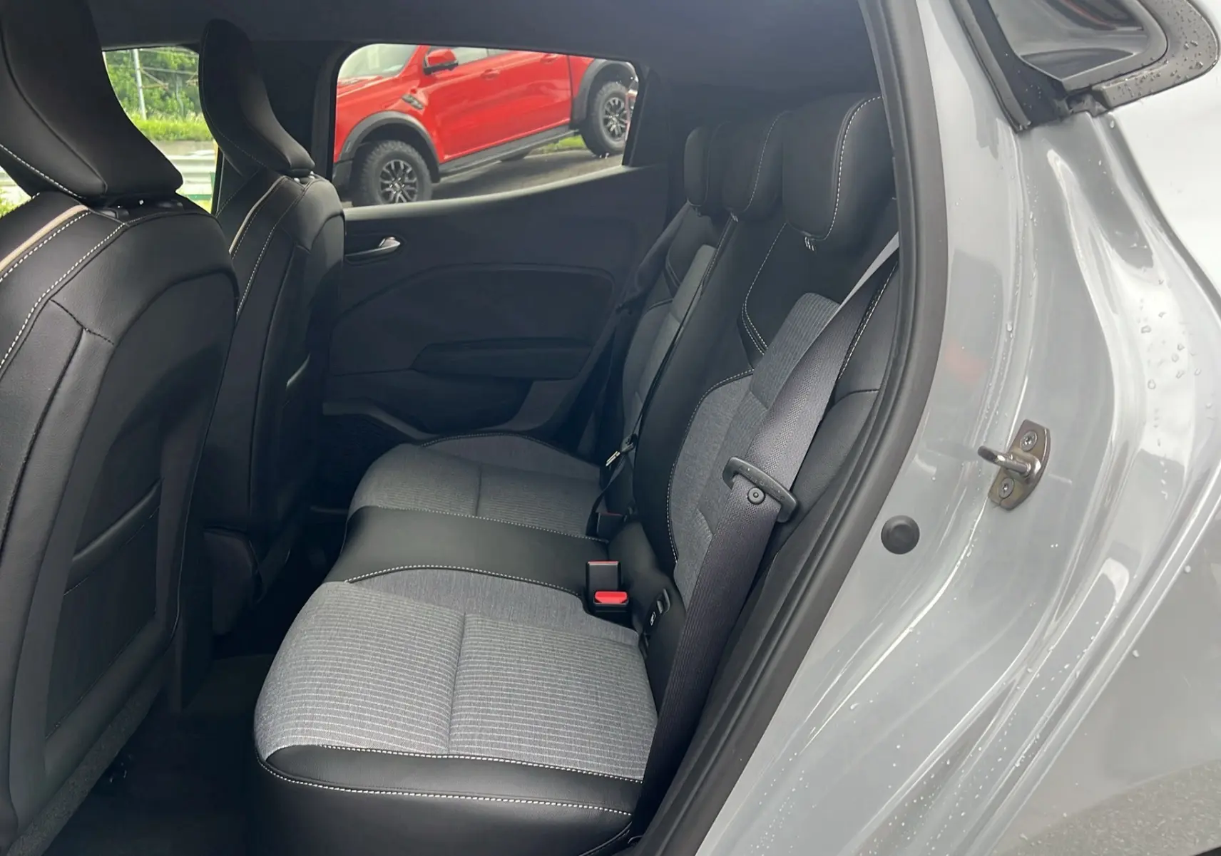 Vue intérieure côté droit des sièges arrière en tissu gris et cuir noir de la Renault Clio V TCe 90 Techno 2025 gris rafale.