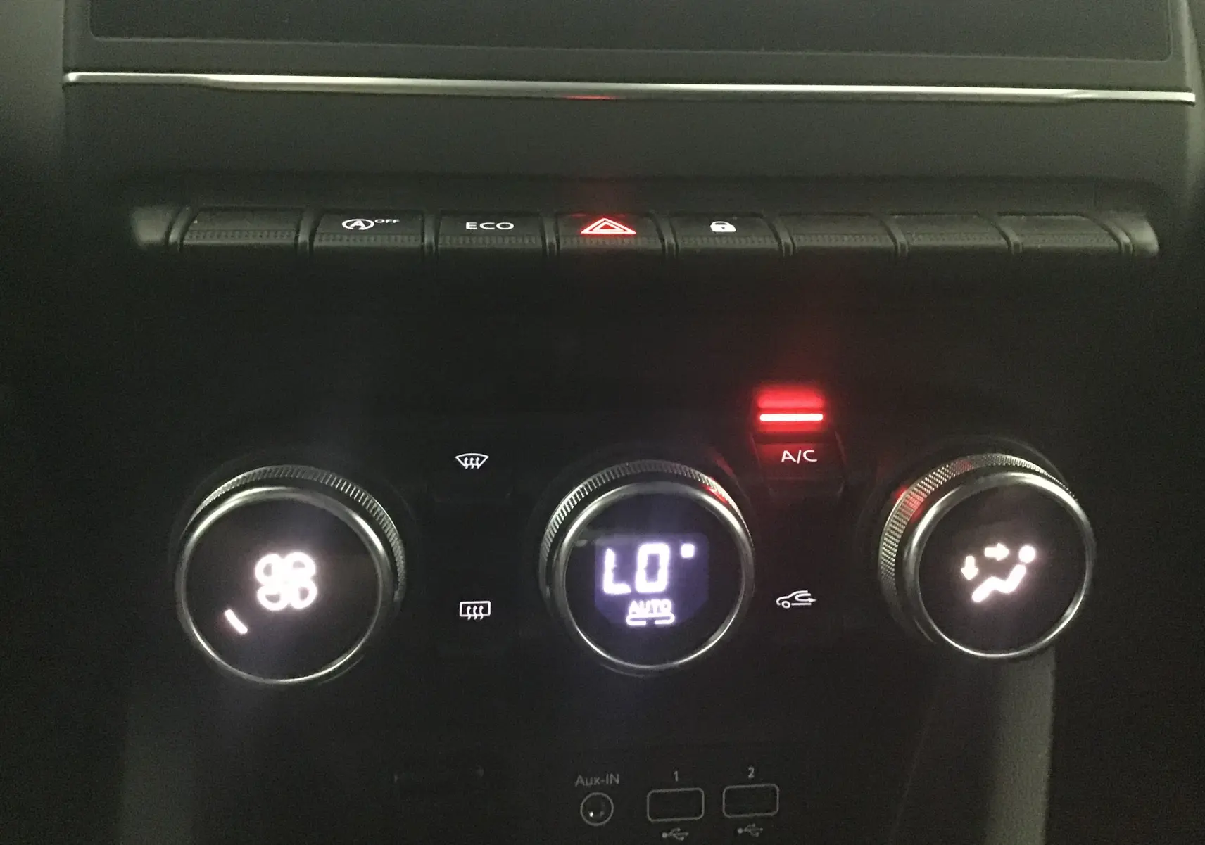 Tableau de bord de Renault Clio V gris platine 2021, zoom sur commandes climatisation avec voyants lumineux allumés.