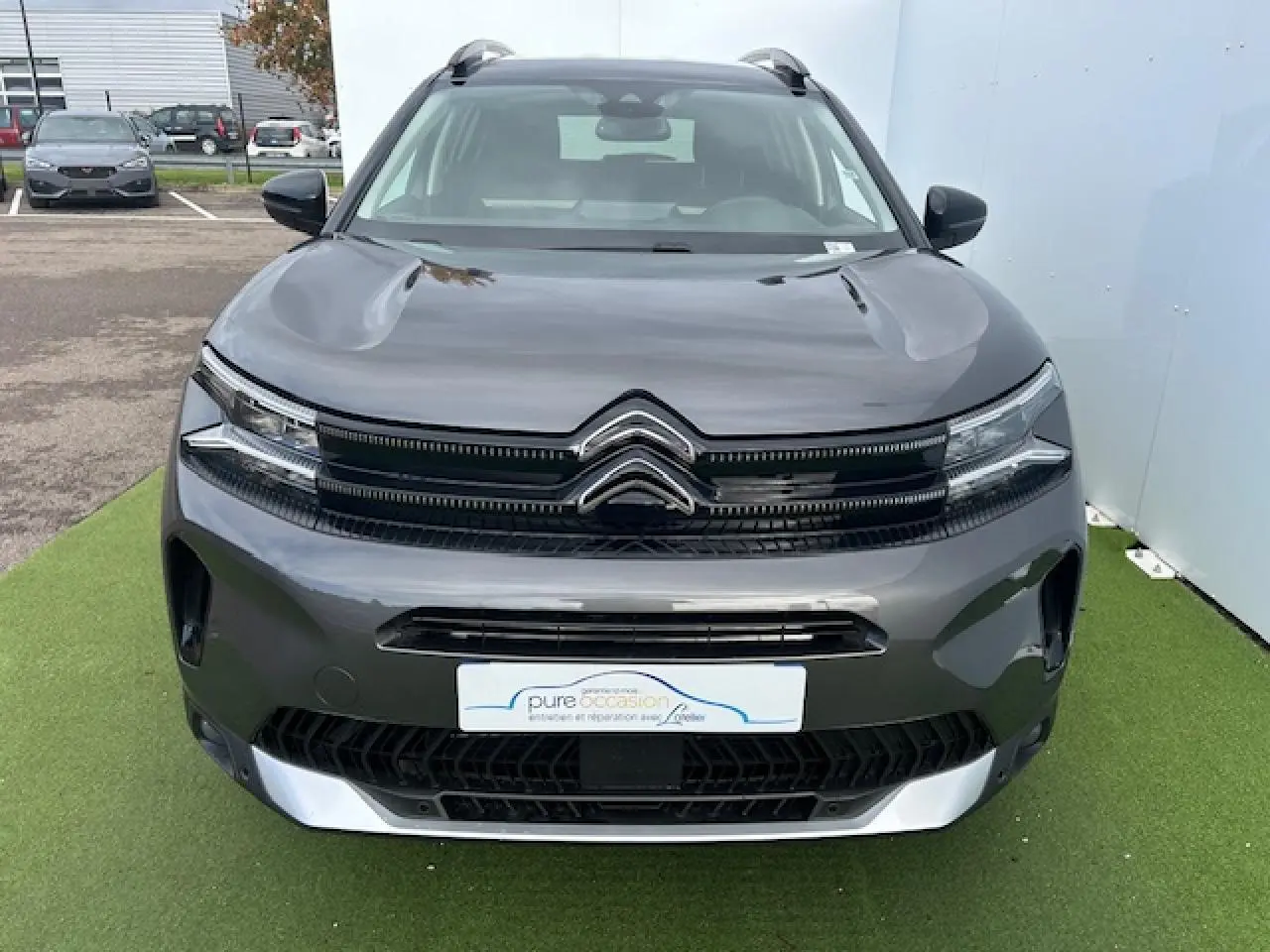 Vue frontale d'un Citroën C5 Aircross gris platinium métallisé avec calandre noir brillant et chevrons chromés.