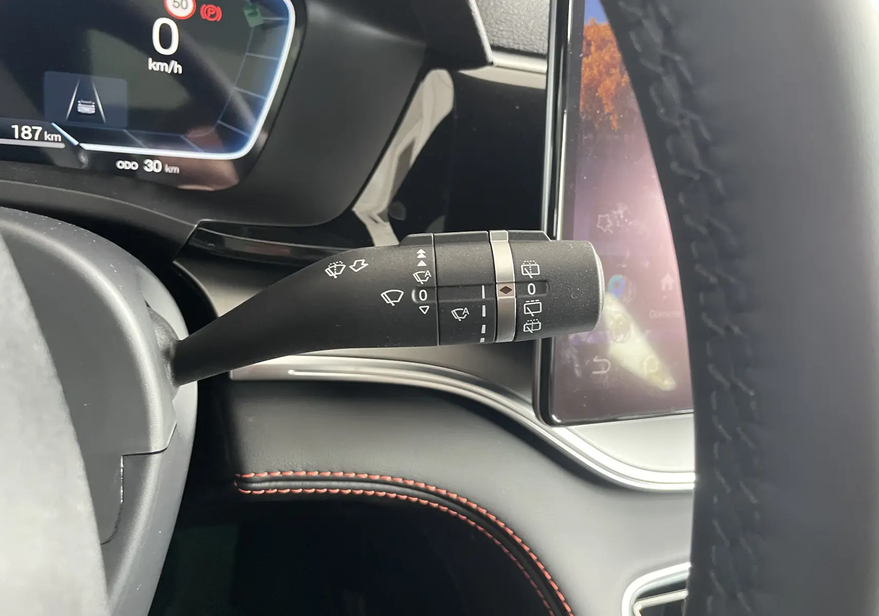 Gros plan sur la manette d’essuie-glace côté droit du tableau de bord du BYD SEAL U 2025, intérieur noir avec surpiqûres rouges.