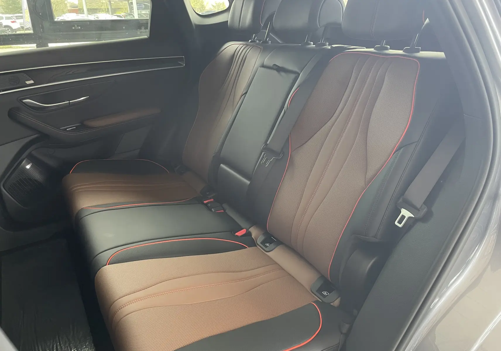 Vue latérale droite des sièges arrière en similicuir noir et marron avec surpiqûres rouges du BYD SEAL U 2025 Time Grey.