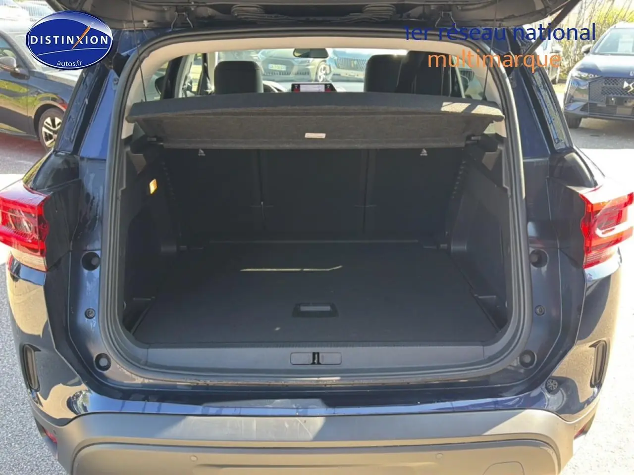 Coffre ouvert vue arrière du Citroën C5 Aircross bleu eclipse 2025 avec hayon et feux arrière LED visibles.