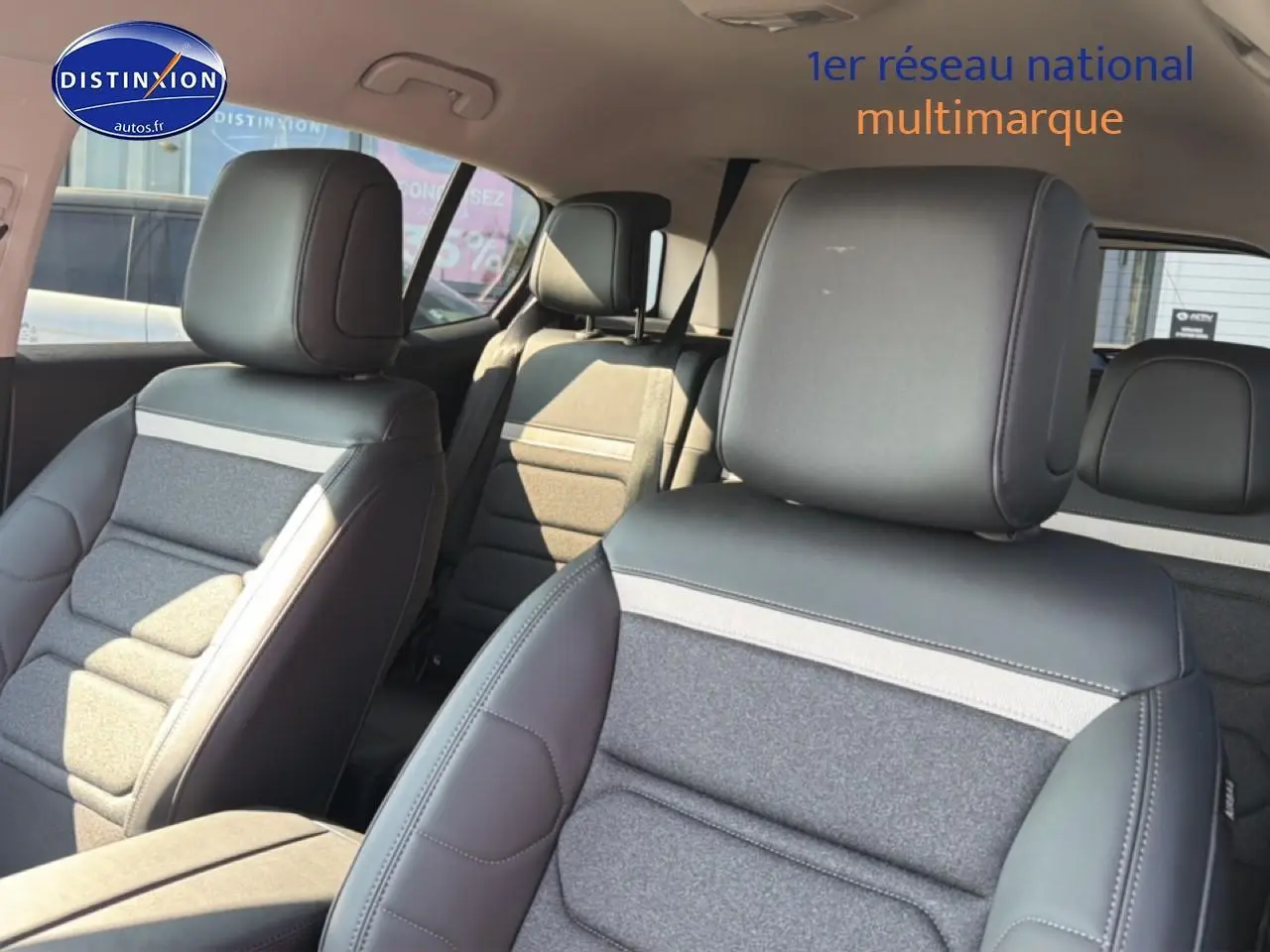 Vue intérieure sur les sièges avant et arrière du Citroën C5 Aircross, tissu gris et cuir noir, ambiance lumineuse naturelle.