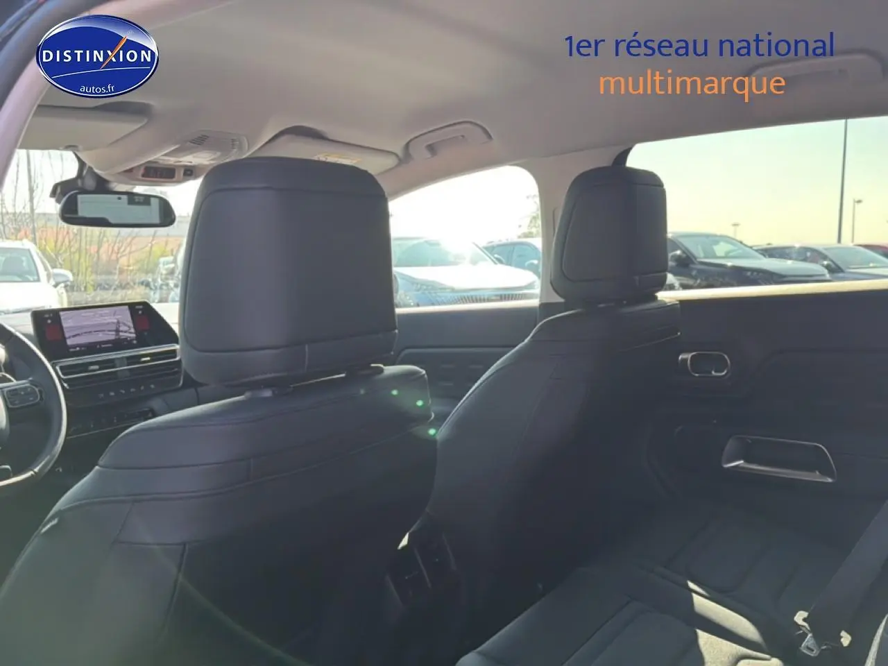 Vue intérieure arrière du Citroën C5 Aircross 2025 bleu eclipse, sièges noirs et tableau de bord avec écran tactile.