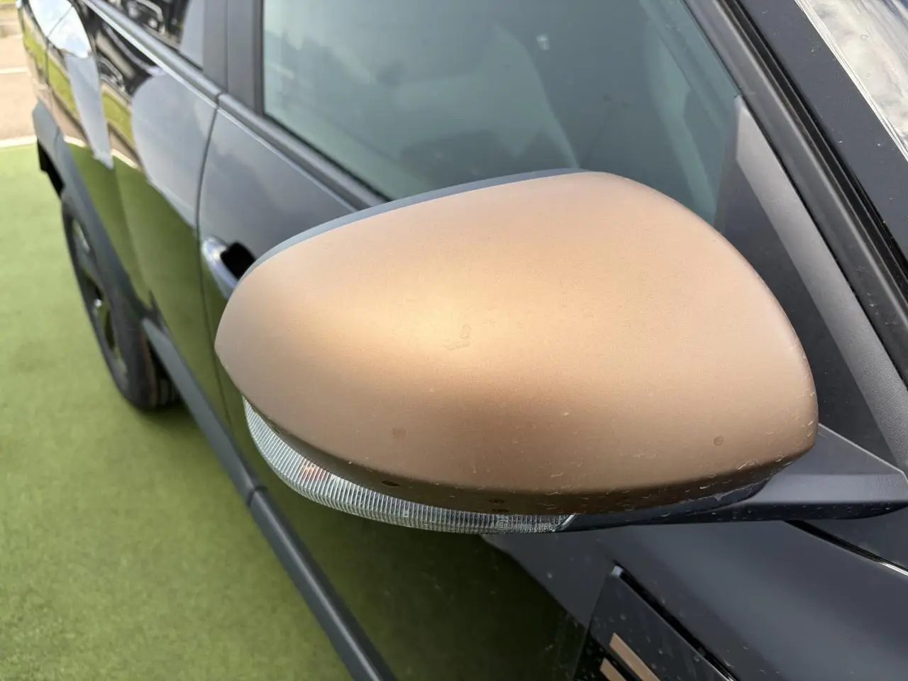 Rétroviseur droit brun cuivré sur Dacia Bigster noir, vue rapprochée côté avant du véhicule.