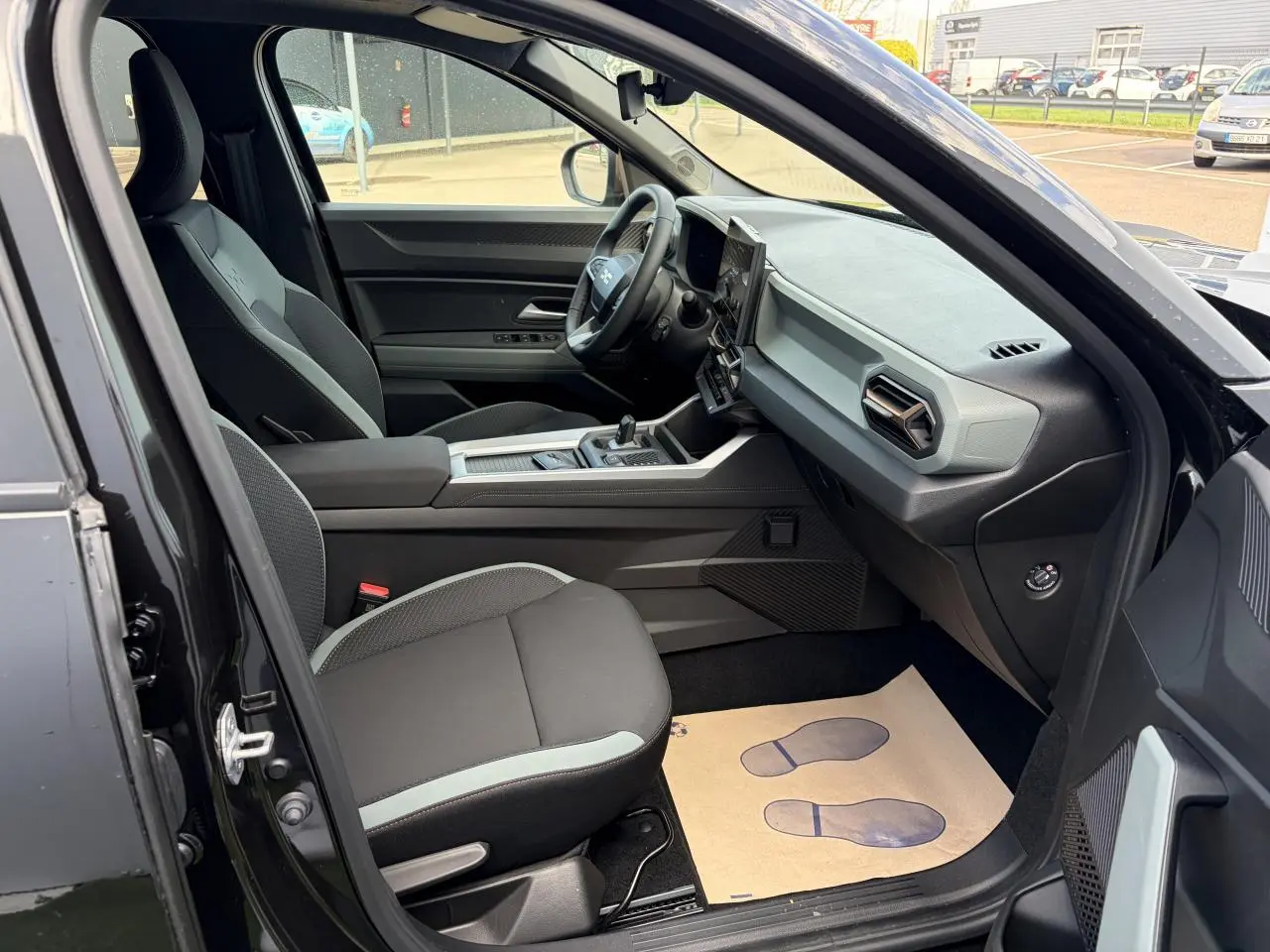 Vue intérieure côté conducteur du Dacia Bigster noir, mettant en valeur la sellerie et le tableau de bord moderne.