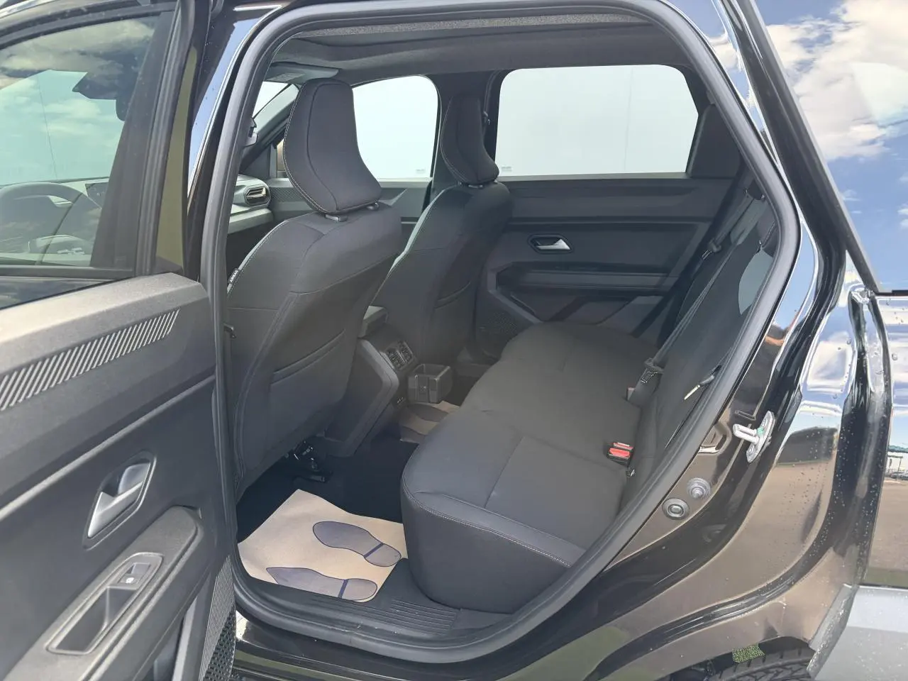 Vue intérieure côté droit de la banquette arrière noire du Dacia Bigster 2026 avec porte ouverte et sellerie TEP MicroCloud.