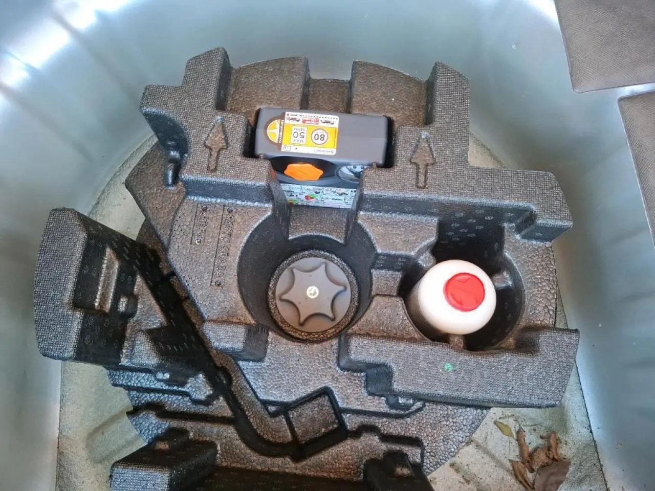Gros plan sur le kit de réparation pneumatique dans le coffre d'une Nissan Micra gris clair 2022.