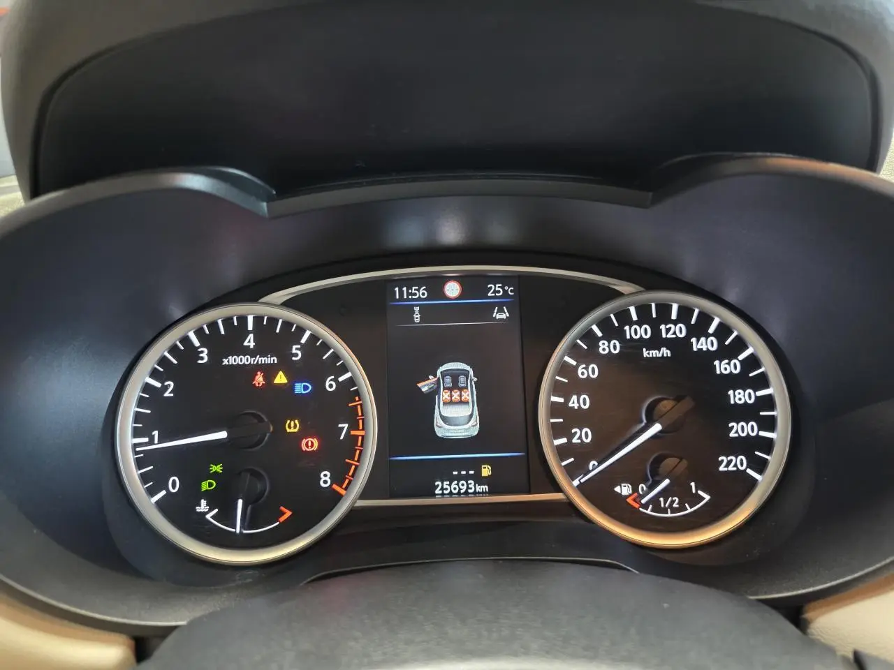 Vue rapprochée du combiné d'instruments de la Nissan Micra gris clair, affichant compte-tours, vitesse et écran central digital.