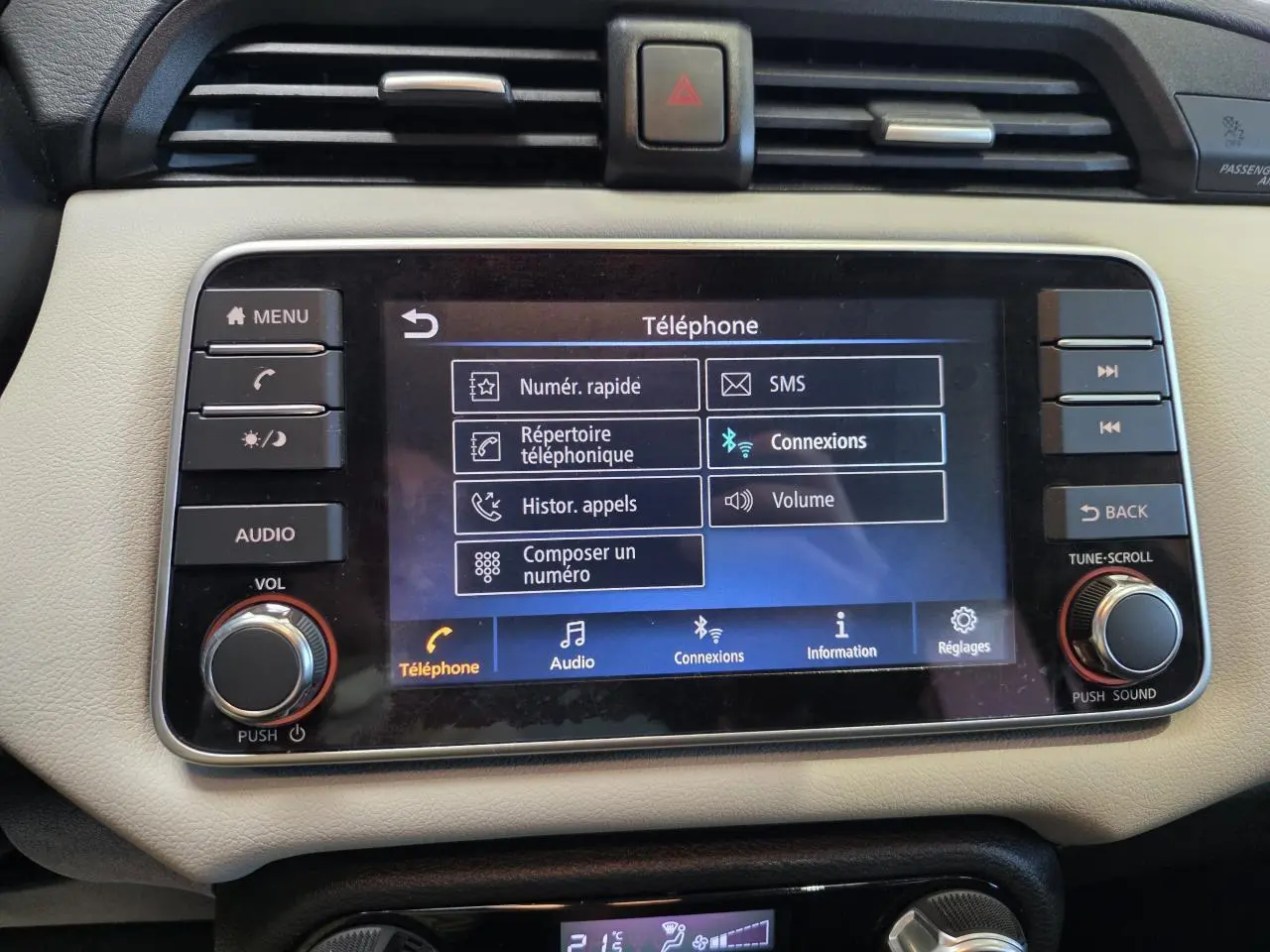 Gros plan sur l'écran tactile central beige de la Nissan Micra 2022 affichant le menu téléphone et les commandes audio.
