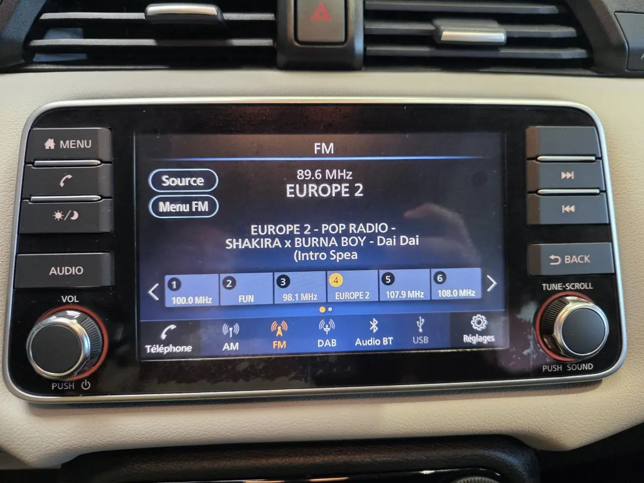 Vue rapprochée de l’écran tactile multimédia 7 pouces de la Nissan Micra Business Edition 2022, tableau de bord beige.