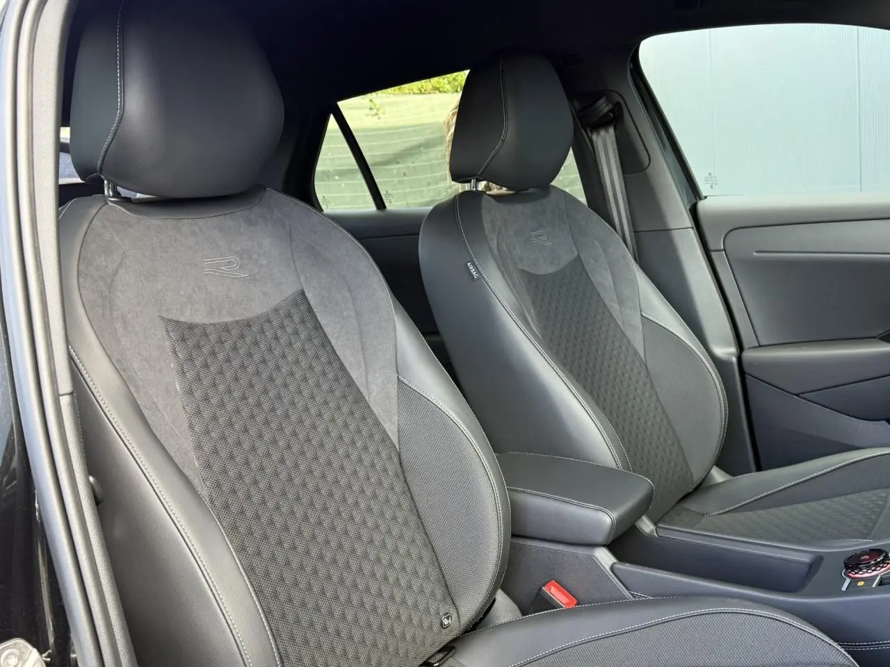 Vue intérieure côté avant droit des sièges sport R-Line en tissu et cuir noir du Volkswagen T-Roc 2026.