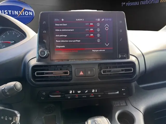 Vue rapprochée du tableau de bord du Peugeot Rifter gris foncé 2020, avec écran tactile central et commandes climatisation digitales.