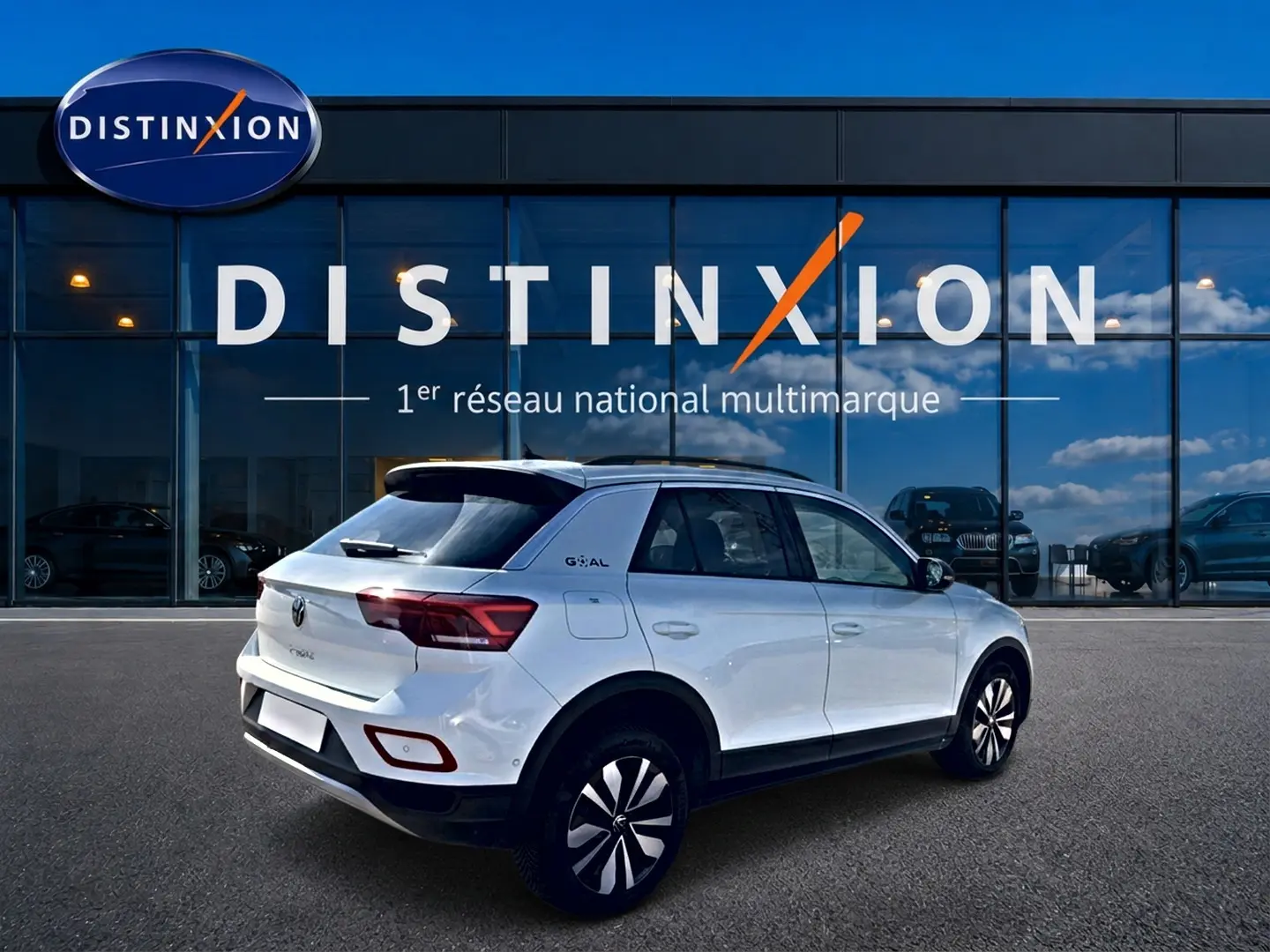 Volkswagen T-Roc blanc vue 3/4 arrière droit, avec jantes alu et toit noir devant showroom Distinxion.