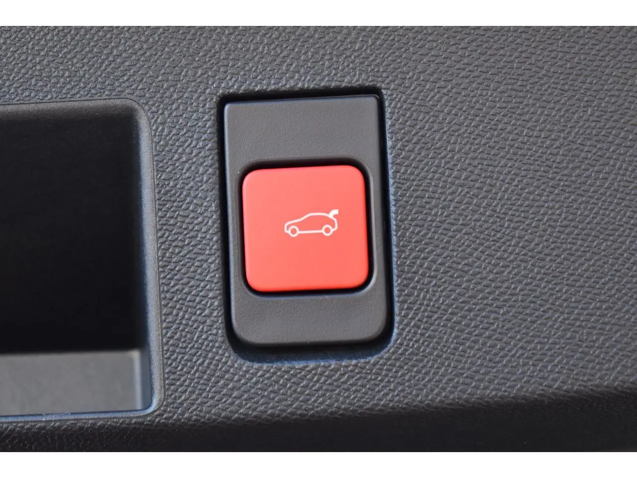 Bouton rouge d'ouverture du hayon motorisé sur panneau intérieur d'une Citroën C5 Aircross gris.