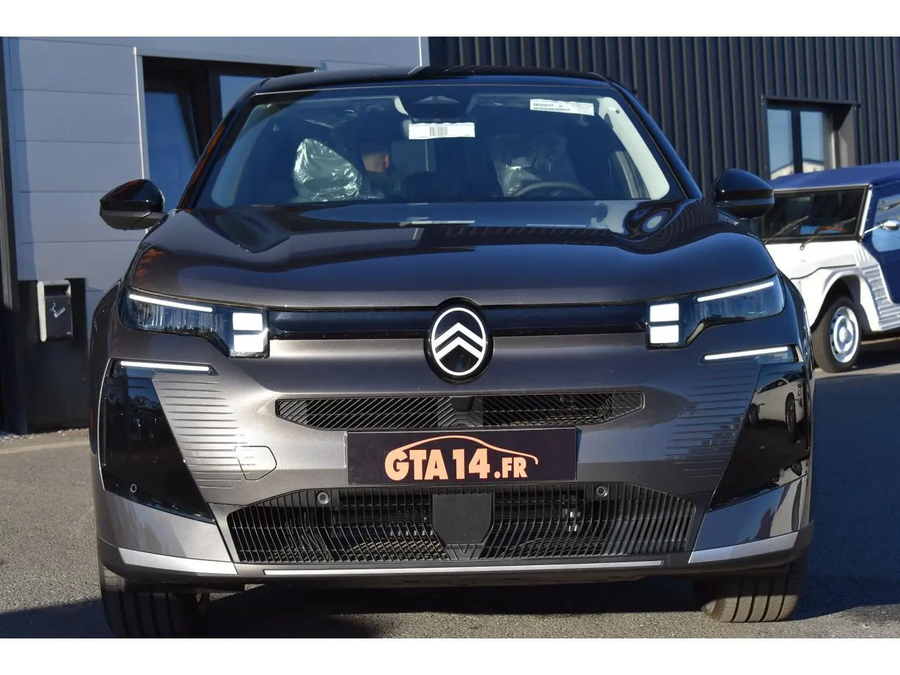 Vue avant d'un Citroën C5 Aircross gris métallisé avec calandre moderne et logo centré, en extérieur.