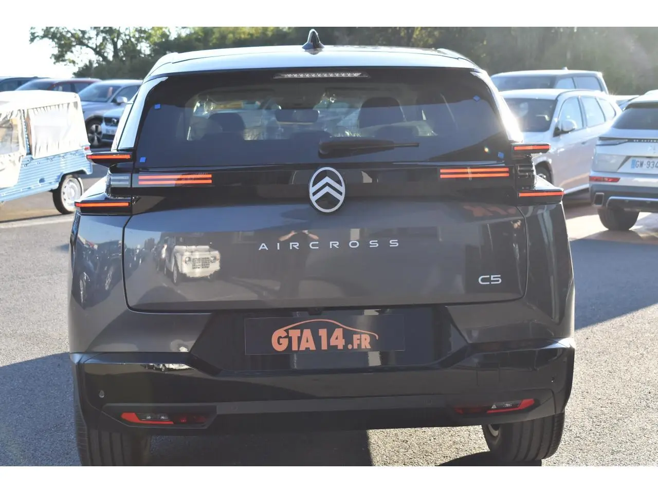 Vue arrière d'un Citroën C5 Aircross gris métallisé avec feux arrière horizontaux et toit bi-ton noir Perla Nera.