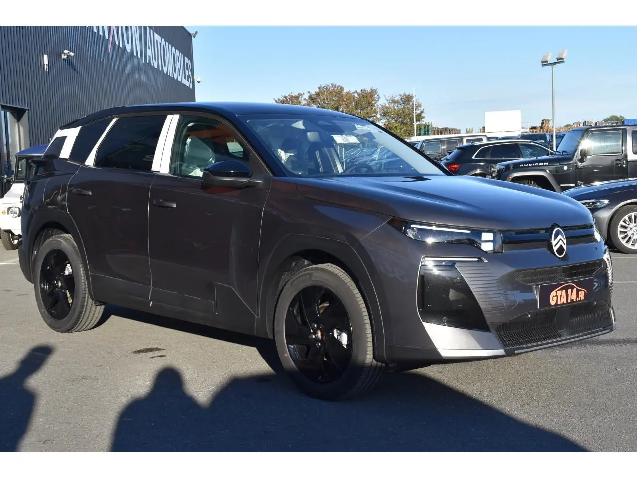 Vue 3/4 avant droit d'un Citroën C5 Aircross hybride gris métallisé avec toit bi-ton noir et jantes noires.