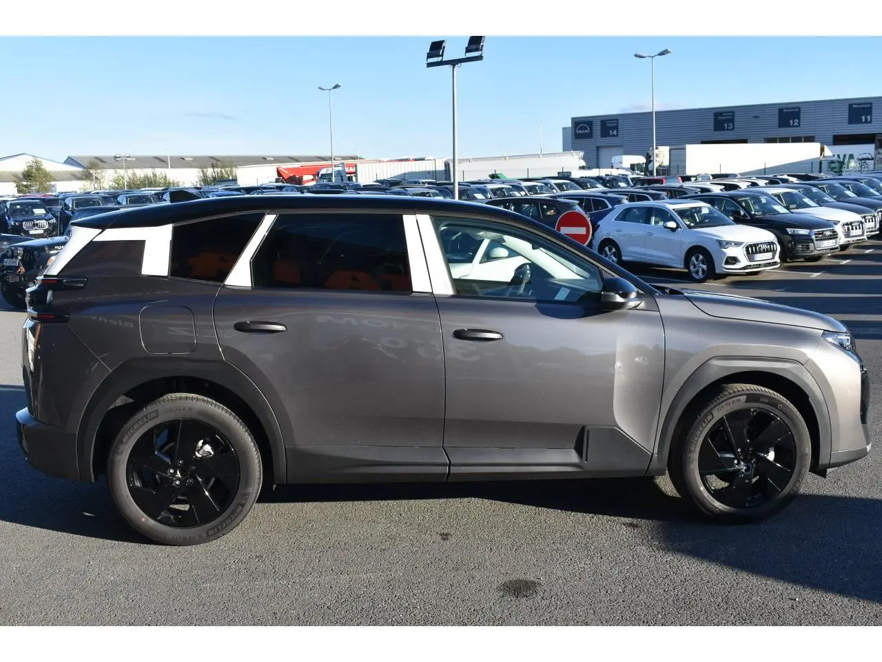 Profil droit d'un Citroën C5 Aircross gris métallisé 2026 avec toit bi-ton noir et jantes noires.