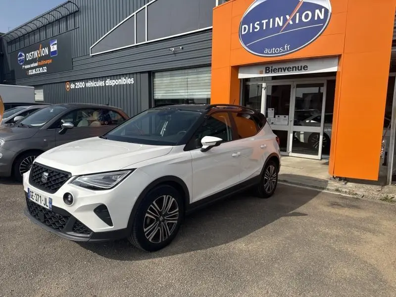 SEAT Arona 1.0 TSI Urban blanc Nevada avec toit gris magnétique, vue 3/4 avant droit devant concessionnaire
