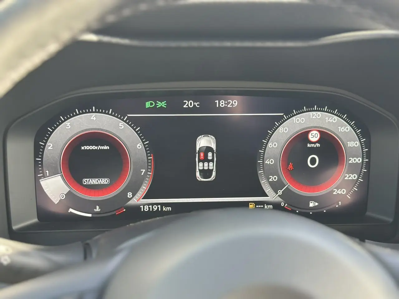 Tableau de bord digital du Nissan Juke 2025, affichant compte-tours, vitesse à zéro et alertes de porte ouverte.