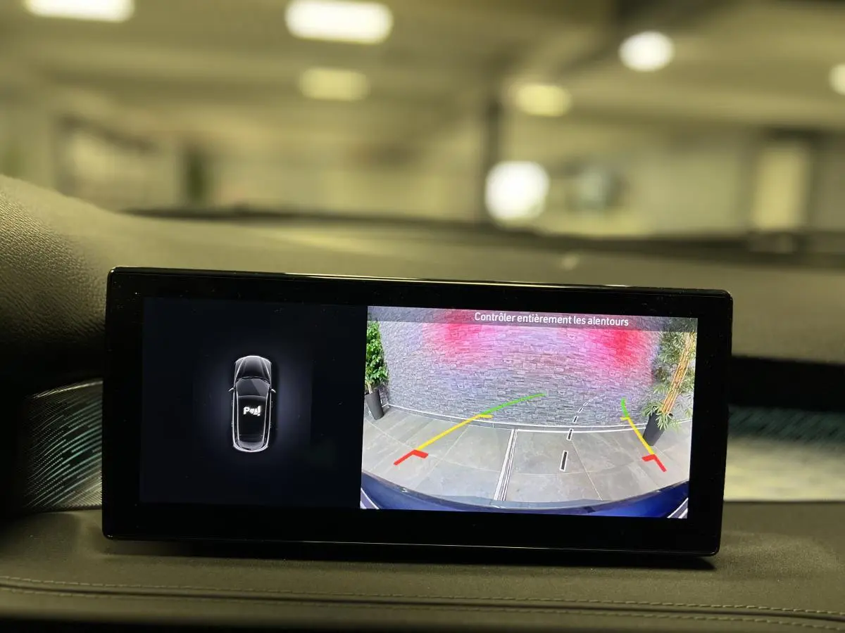 Écran du système multimédia affichant la caméra de recul et l'aide au stationnement de l'Alfa Romeo Tonale gris foncé.