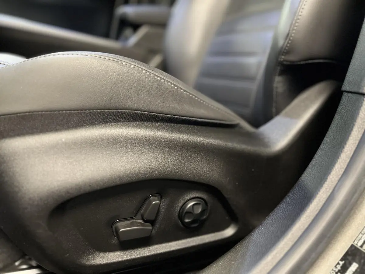 Détail des commandes de réglage électrique du siège en cuir noir côté conducteur de l'Alfa Romeo Tonale 2022.