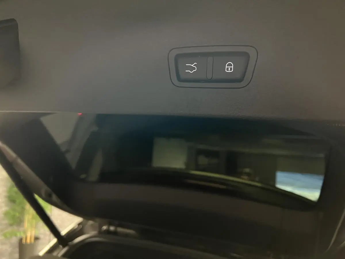 Bouton d'ouverture et de verrouillage du hayon électrique sur le coffre d'une Alfa Romeo Tonale gris foncé.