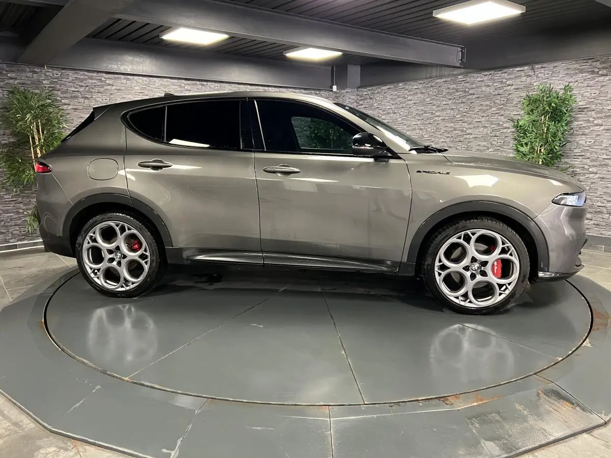 Profil droit de l'Alfa Romeo Tonale 1.5 mHEV gris foncé avec jantes 20 pouces et étriers Brembo rouges visibles.