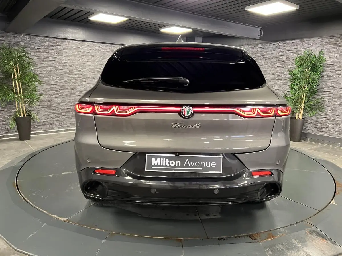 Vue arrière d'une Alfa Romeo Tonale gris foncé avec feux LED reliés et double sortie d'échappement noire.