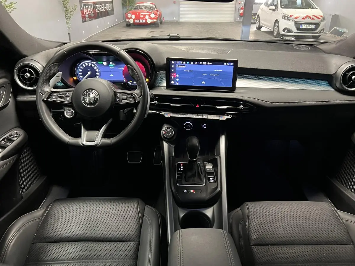 Intérieur noir de l'Alfa Romeo Tonale 2022, vue frontale sur le volant cuir et l'écran tactile central.