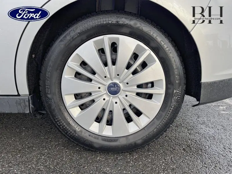 Gros plan sur la roue avant droite d'une Ford C-MAX gris lunaire avec enjoliveur argenté et pneu All Climate.