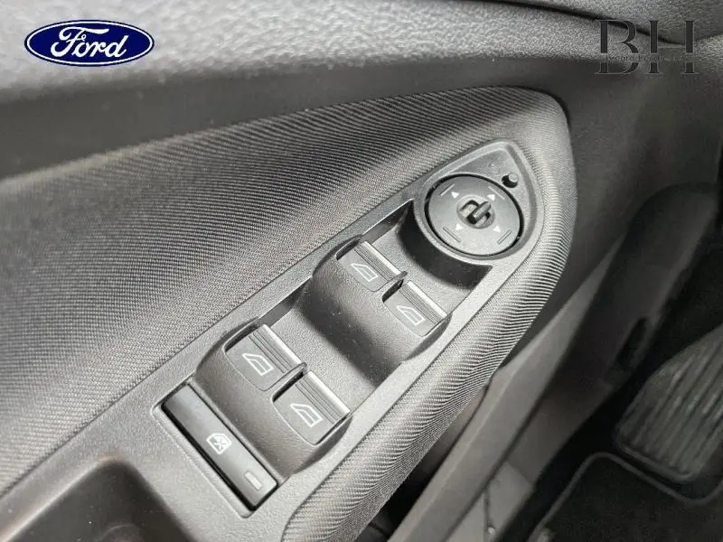 Gros plan sur les commandes de lève-vitres et rétroviseurs côté conducteur d’une Ford C-MAX gris lunaire, intérieur noir.