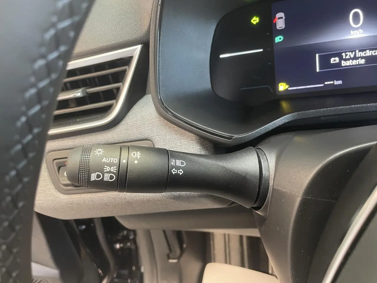 Gros plan sur la commande des phares et clignotants côté gauche du tableau de bord de la Renault Clio noire étoile 2025.