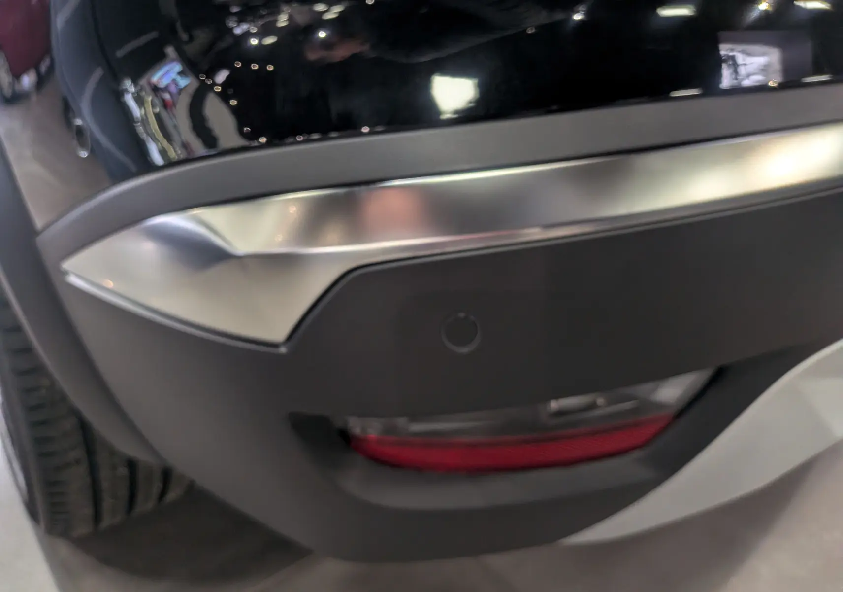 Gros plan sur le pare-chocs arrière droit noir étoilé du Renault Symbioz E-Tech 160 ch avec feu antibrouillard intégré.