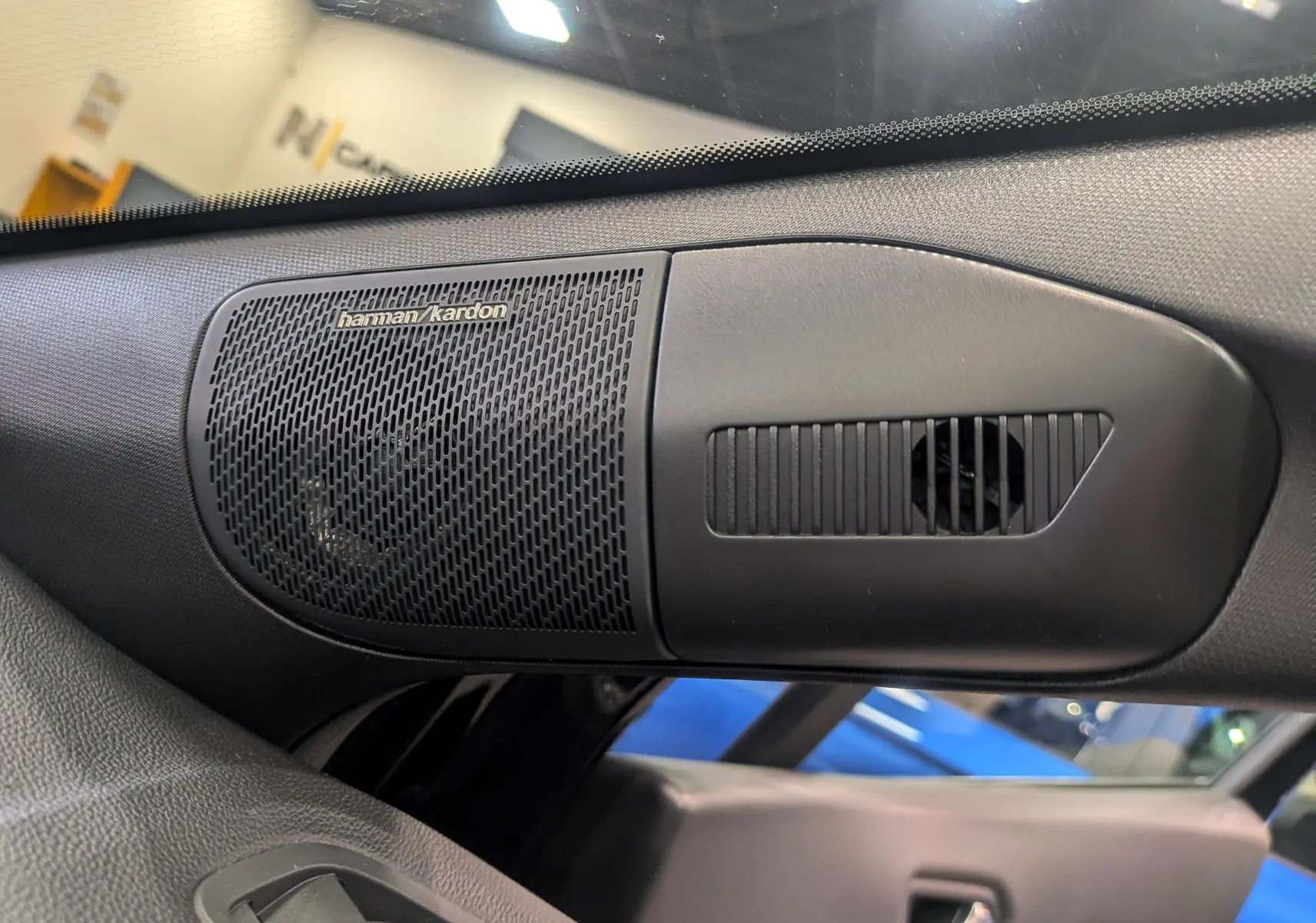 Gros plan sur l'enceinte Harman Kardon intégrée dans la garniture intérieure côté gauche du Renault Symbioz noir étoilé 2026.