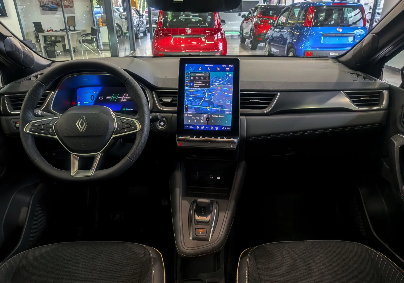 Intérieur de la Renault SYMBIOZ E-Tech 160 ch, vue frontale du tableau de bord avec écran tactile vertical et volant multifonction.