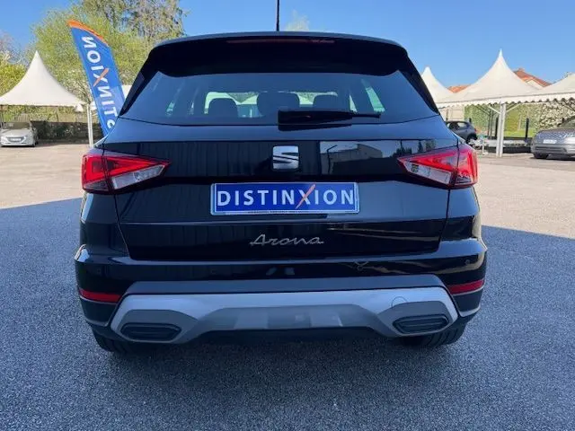 Vue arrière d'un SEAT Arona noir avec toit gris, feux arrière LED et logo distinctif sur parking extérieur.