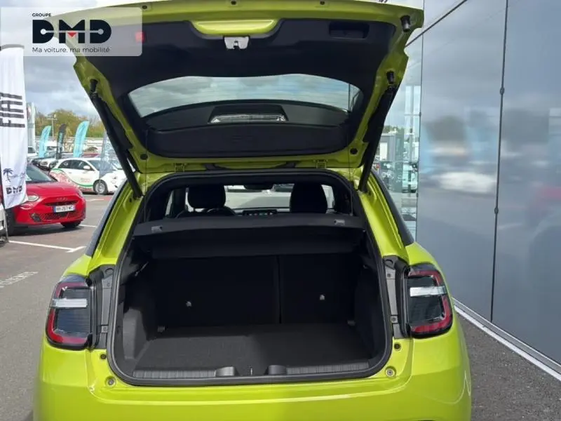 Vue arrière ouverte sur le coffre d'une FIAT 600 vert Méditerranéen métallisé avec toit noir, en extérieur.