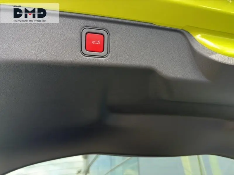 Bouton rouge d'ouverture de coffre sur le bord intérieur du hayon vert Méditerranéen métallisé d'une FIAT 600 hybride.
