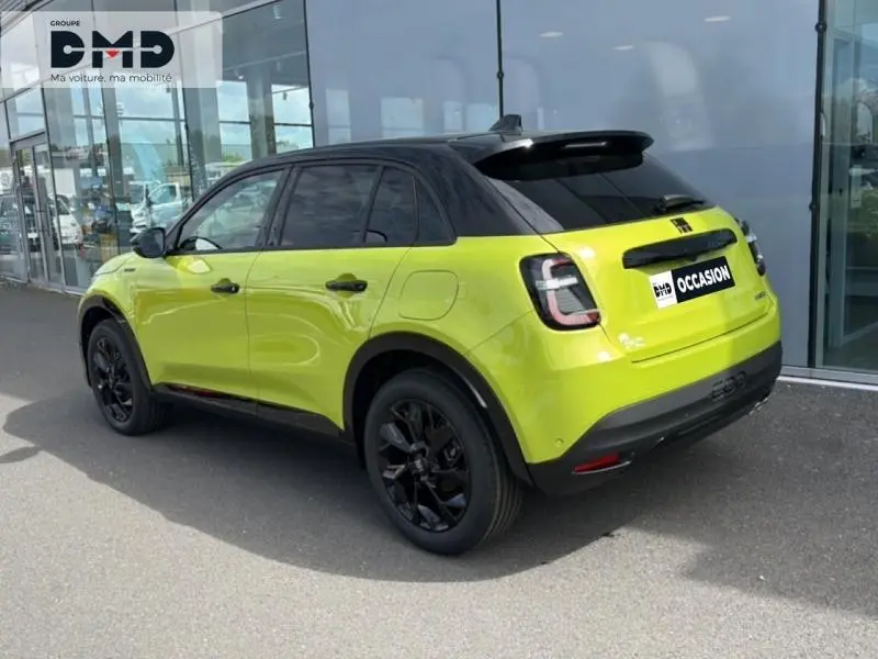 Vue 3/4 arrière droite d'une FIAT 600 vert Méditerranéen métallisé avec toit noir et jantes noires brillantes.