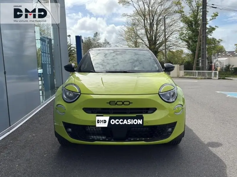 Vue avant d'une FIAT 600 vert Méditerranéen métallisé avec toit noir, phares ronds et calandre noire distinctive.