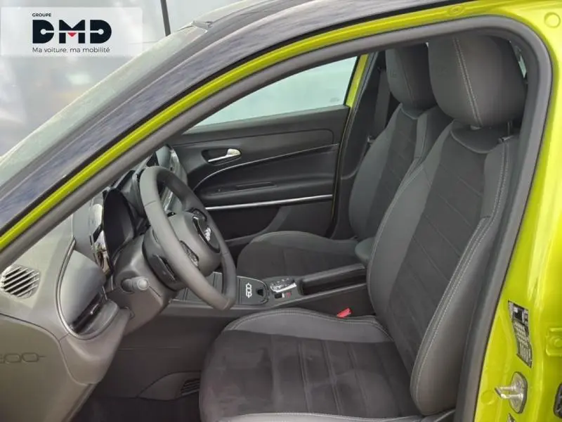 Vue intérieure côté conducteur de la FIAT 600 vert Méditerranéen avec sièges noirs et volant multifonction.