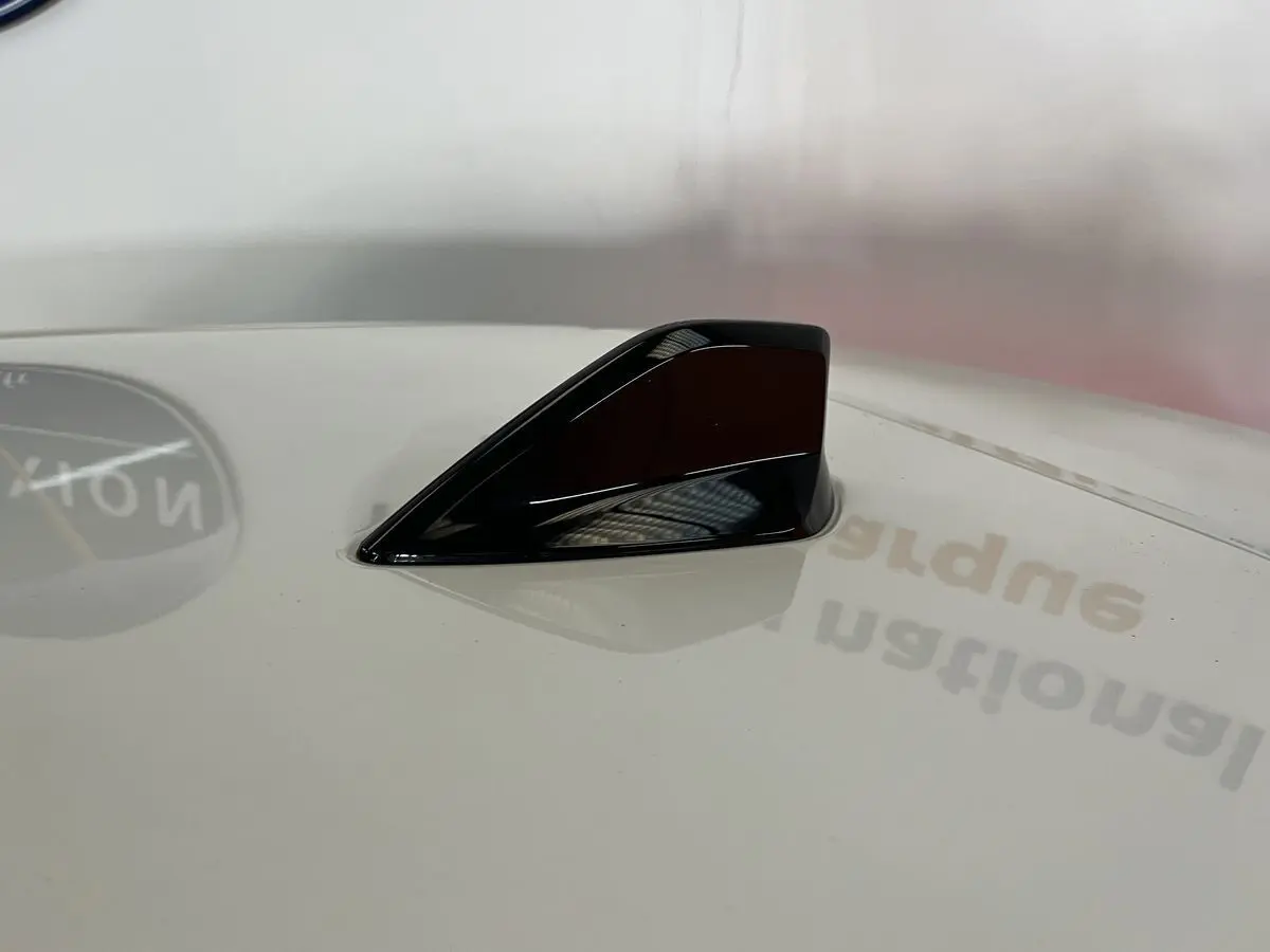 Antenne requin noire sur toit blanc nacré d'une Peugeot 308 GT PHEV 2022, vue rapprochée en plongée.
