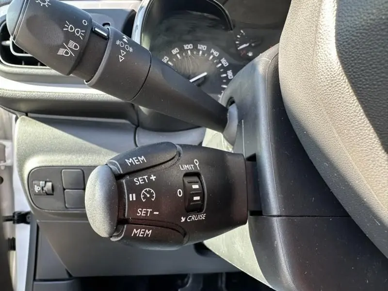 Gros plan sur la commande de régulateur de vitesse dans l'habitacle d'une Citroën C3 blanc toit rouge, version 2021.