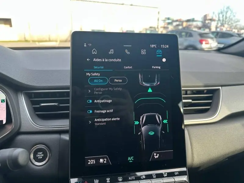 Vue intérieure centrée sur l'écran tactile du tableau de bord du Renault Captur 2025, affichant les aides à la conduite.
