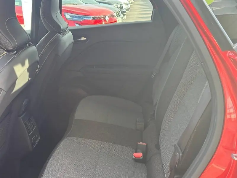 Vue intérieure côté droit des sièges arrière du Renault Captur 2025 Rouge Flamme avec détails tissu gris et noir.