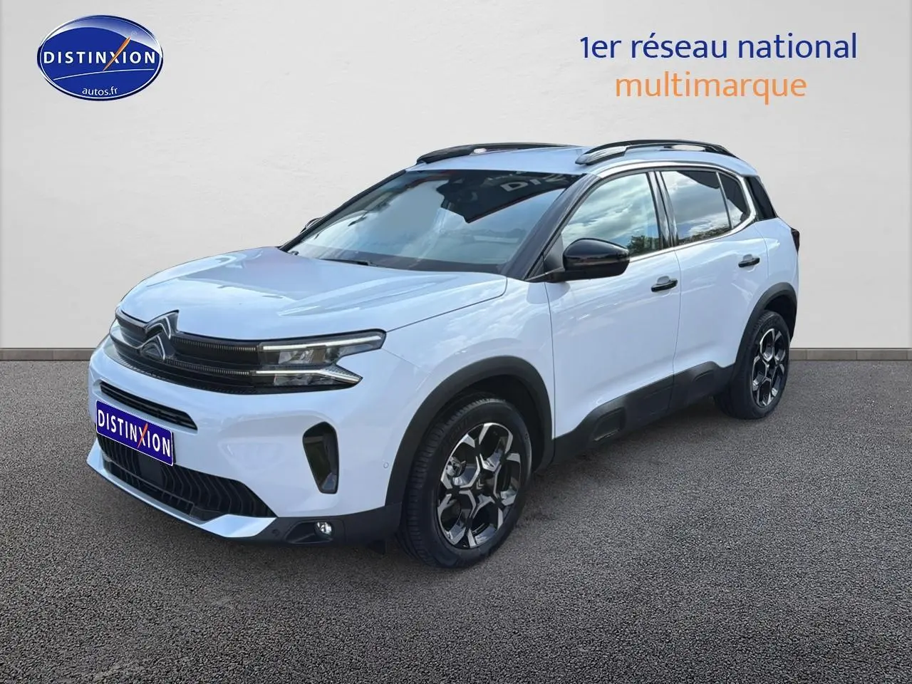 Citroën C5 Aircross blanc vue 3/4 avant droit avec jantes alu et barres de toit noires.