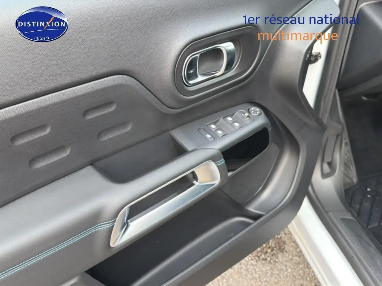 Détail de la porte avant gauche noire avec poignée chromée et commandes des vitres sur Citroën C5 Aircross blanc.