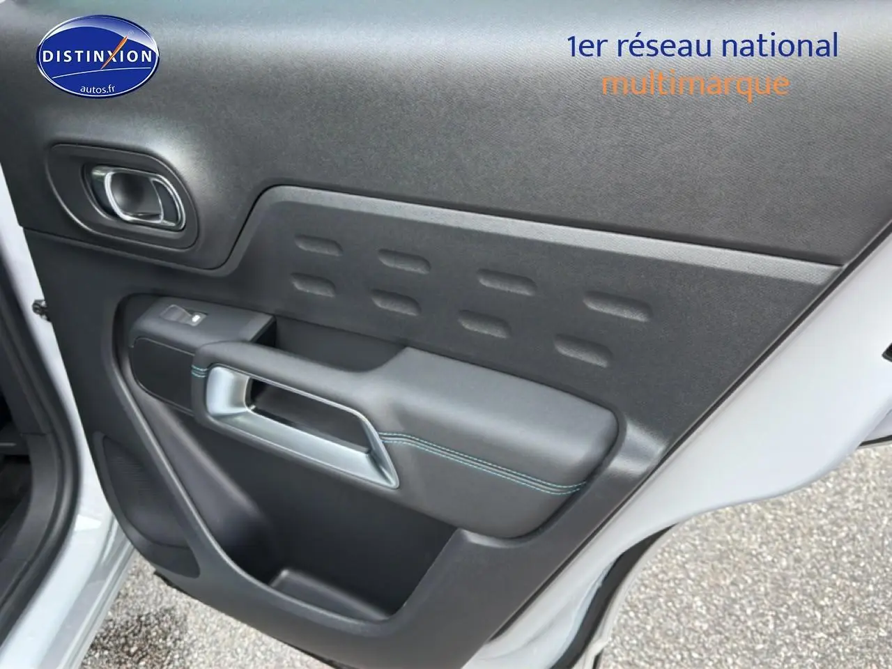 Vue rapprochée de la porte arrière gauche blanche du Citroën C5 Aircross avec panneau intérieur noir et surpiqûres bleues.